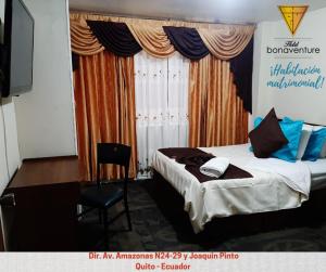 a bedroom with a bed and a desk with a computer at Hotel Bonaventure in Quito