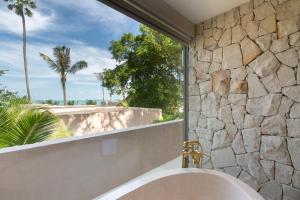 eine Badewanne im Bad mit einem großen Fenster in der Unterkunft Cielo Boutique Hotel & Spa Samui in Bophut  + 37 Fotos