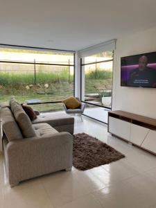 sala de estar con sofá y TV de pantalla plana en CASA MONTEBELLO CON PISCINA PRIVADA EN LA MESA en La Mesa