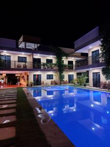 a swimming pool in front of a building at night at Harmonia Flats in Pipa