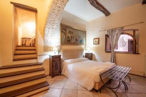 ein Schlafzimmer mit einem Bett und einer Treppe in einem Zimmer in der Unterkunft HOTEL TREVI Palazzo Natalini in Trevi