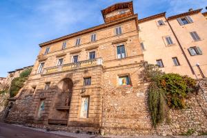 un antiguo edificio de piedra con una persona en la ventana en HOTEL TREVI Palazzo Natalini, en Trevi