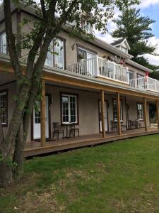 uma casa com um deque e uma varanda em Orange Bistro em Baie-Saint-Paul