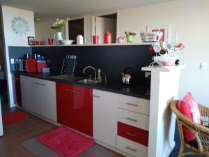 a kitchen with red and white cabinets and a sink at Belle Vista in Wirrina Cove