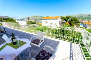 uma varanda com uma mesa e cadeiras e uma vista em Apartments Iva - 150m from the beach em Trogir