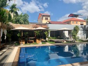 a villa with a swimming pool and a house at Babel Siem Reap Guesthouse in Siem Reap
