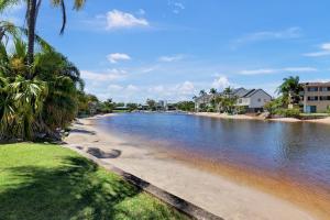 莫羅拉巴海濱的住宿－HACIENDA- CANAL VIEWS AND COMFORT，一片棕榈树海滩,毗邻一片水域