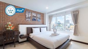 um quarto com uma cama e uma parede de tijolos em U Hatyai Hotel em Hat Yai