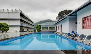 a swimming pool in the backyard of a house at Treebo Trend Misty Garden Resorts With Mountain View in Munnar