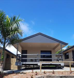 a house with two benches and a palm tree at Hay Point Hotel/Motel in Hay Point