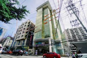 um edifício alto com janelas de vidro numa rua da cidade em Goldberry Suites and Hotel Cebu em Cebu