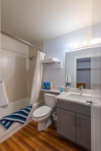 ein Badezimmer mit Toilette, Waschbecken und Spiegel in der Unterkunft 4 Bedrooms Suite Combo for Group of Families - Windtower Lodge in Canmore