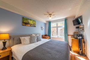 ein Schlafzimmer mit einem Bett und einem Fenster in der Unterkunft 4 Bedrooms Suite Combo for Group of Families - Windtower Lodge in Canmore