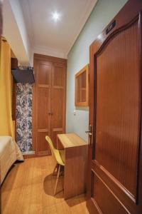 a kitchen with a wooden floor and wooden cabinets at Pension Angelines, Sneuu Hostel Santander in Santander
