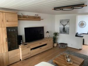 een woonkamer met een groot entertainmentcentrum met een flatscreen-tv bij Ferienwohnung Nicole in Bad Harzburg