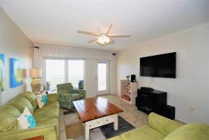 ein Wohnzimmer mit einem Sofa und einem Flachbild-TV in der Unterkunft Edgewater Condo Unit #304 in South Padre Island