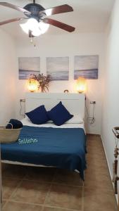 a bedroom with a blue bed with a ceiling fan at Apartamento "SA VIEIRA" BLANES COSTA BRAVA in Blanes