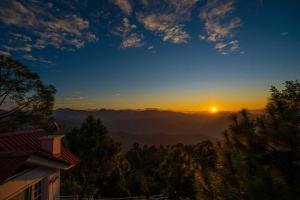 a view of the sunset from a house at StayVista at The Haven 3BR Villa in Kasauli with Scenic Panoramic Views in Kasauli