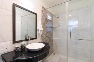 a bathroom with a sink and a glass shower at StayVista at The Haven in Kasauli