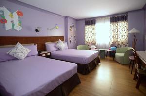Habitación de hotel con 2 camas y mesa en The Golden Pine Hotel, en Baguio