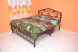 uma cama num quarto com uma colcha em Ballaleshwar cottage em Alibag