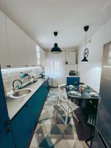 a kitchen with a sink and a table with chairs at Apartment One Brasov in Braşov