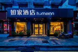 een brommer geparkeerd voor een winkel bij Home Inn Changsha Railway Station Bayi Road in Changsha