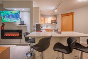 a kitchen with a counter and a fireplace at Top Floor Condo - 2BR & AC with Mountain Views in Canmore