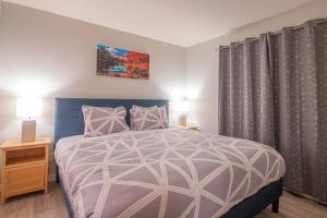 una camera con un grande letto e due lampade di Mountain View 2 Bedroom Condo - WT Top Floor-401 a Canmore