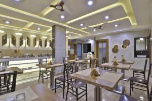 a restaurant with tables and chairs and a bar at Hotel Pearl in Vadodara
