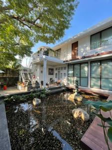 a house with a pond in front of it at JARITT NyMMANH in Chiang Mai