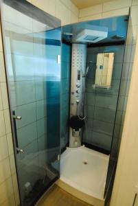 a shower in a bathroom with a glass door at Kotedžas prie jūros in Palanga
