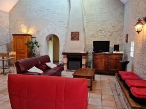 a living room with a red couch and a fireplace at Gîte Donnery, 4 pièces, 6 personnes - FR-1-590-23 in Donnery