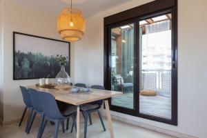 a dining room with a wooden table and blue chairs at Penthouse La Cala De Mijas in La Cala de Mijas