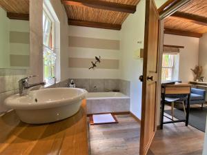 a bathroom with a large tub and a sink at Swellendam Country Lodge - Guest House - B&B in Swellendam