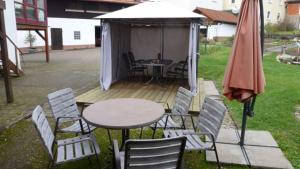 un patio con mesa, sillas y sombrilla en Ferienwohnung Irene, en Ludwigschorgast