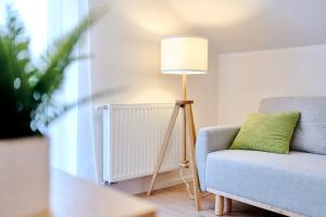 波蘭尼卡－茲德魯伊的住宿－LAGUNA Apartament Polanica Residence 54，蓝色椅子旁边的一盏灯,上面有绿色枕头