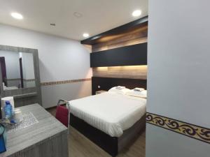 ein Hotelzimmer mit einem Bett und einem Waschbecken in der Unterkunft TAMU KoGURU in Jertih