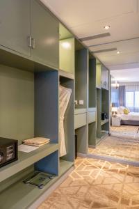 Habitación con armarios verdes y sala de estar. en Manhattan Business Hotel, Male en Male