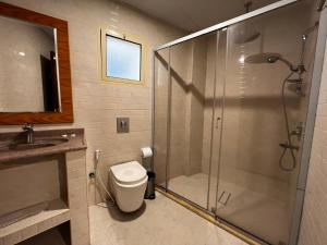 a bathroom with a shower and a toilet and a sink at Traveller Inn Hotel Appartments in Al Khobar