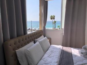 Schlafzimmer mit einem Bett und Strandblick in der Unterkunft Hotel Room Service in Bat Yam