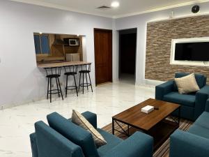 a living room with blue chairs and a table at Traveller Inn Hotel Appartments in Al Khobar