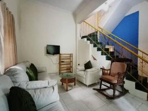 a living room with two couches and a staircase at Ivy Cosy House, 2 BHK, Khandala in Khandāla