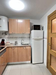 a kitchen with a white refrigerator and a sink at Bellas Artes in Murcia