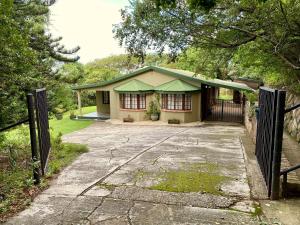 uma casa com um portão em frente em Berg Escape Kiepersol - Spacious Luxury Family Home em Winterton