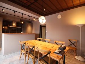 a dining room with a wooden table and chairs at 元町の宿　雪月花 in Hakodate
