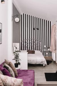 um quarto com uma cama e uma parede listrada a preto e branco em Alandala by The Center em Cluj-Napoca