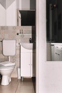 a bathroom with a toilet and a sink at Alandala by The Center in Cluj-Napoca