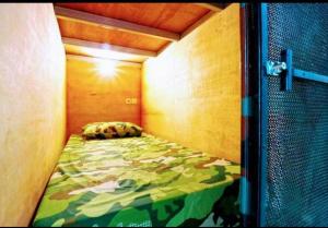 ein kleines Schlafzimmer mit einem Bett in einem Zimmer in der Unterkunft Kabin Kapsule UI Depok - Male Only in Jakarta