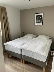 una camera da letto con un grande letto con lenzuola bianche di Appartments Eutiner Seepark a Eutin